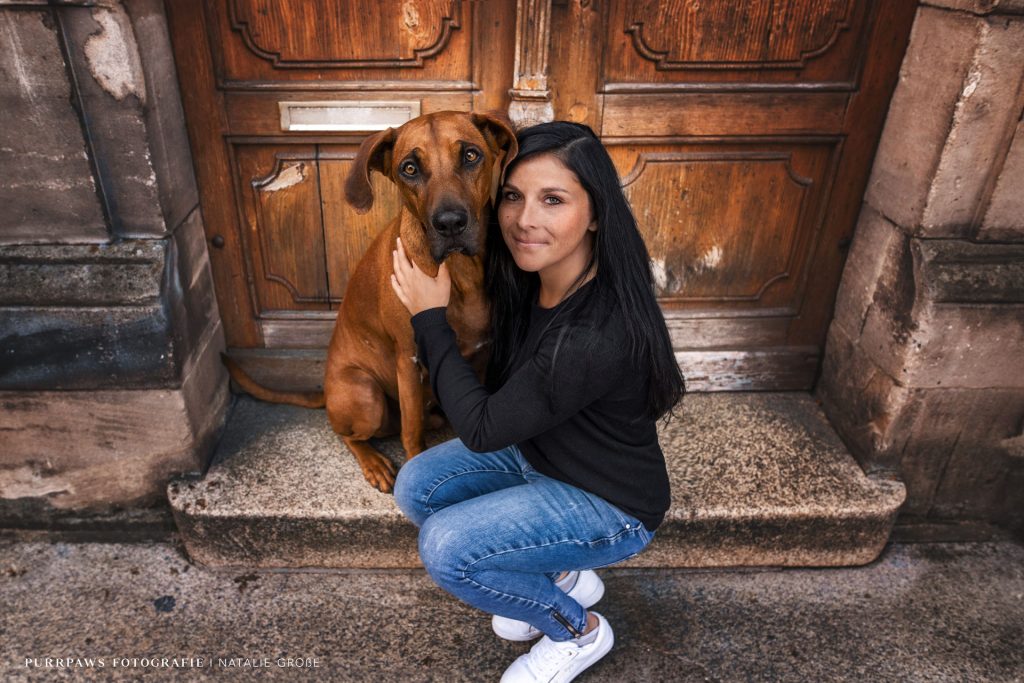 Therapeutin sitzt mit Hund auf Treppe